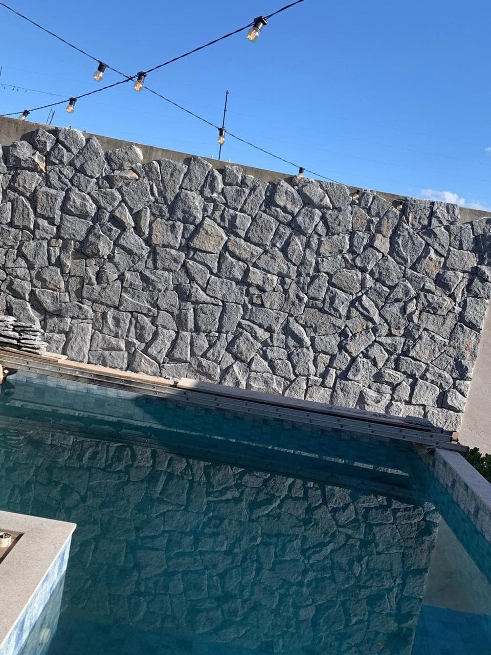 Parede de pedra natural junto à piscina