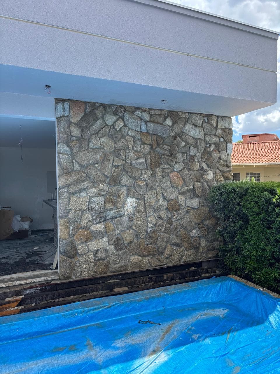 Volume externo de residência revestido em pedra natural junto à área de piscina